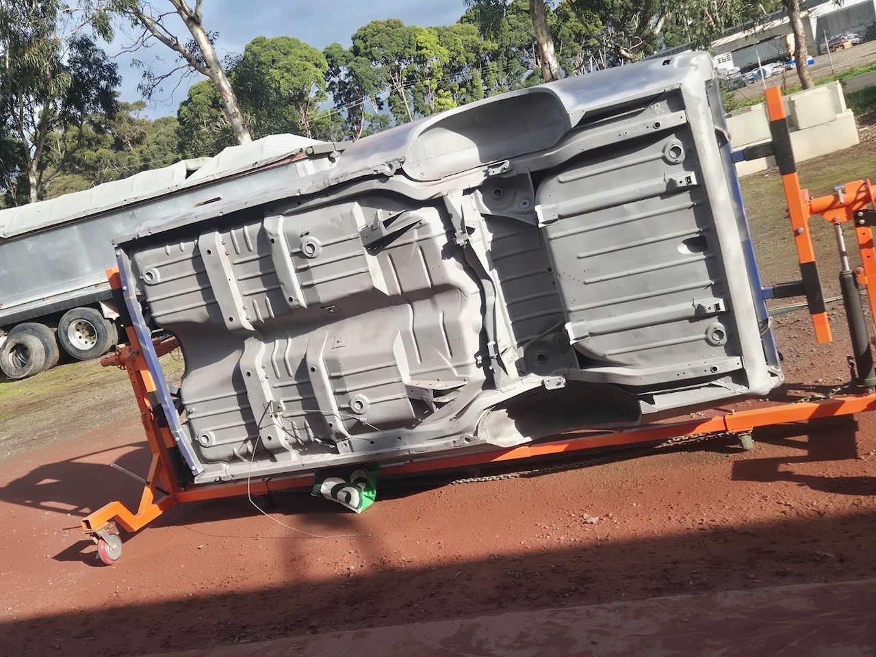 Car body shell on a rotisserie, blasted back to uniform bare metal